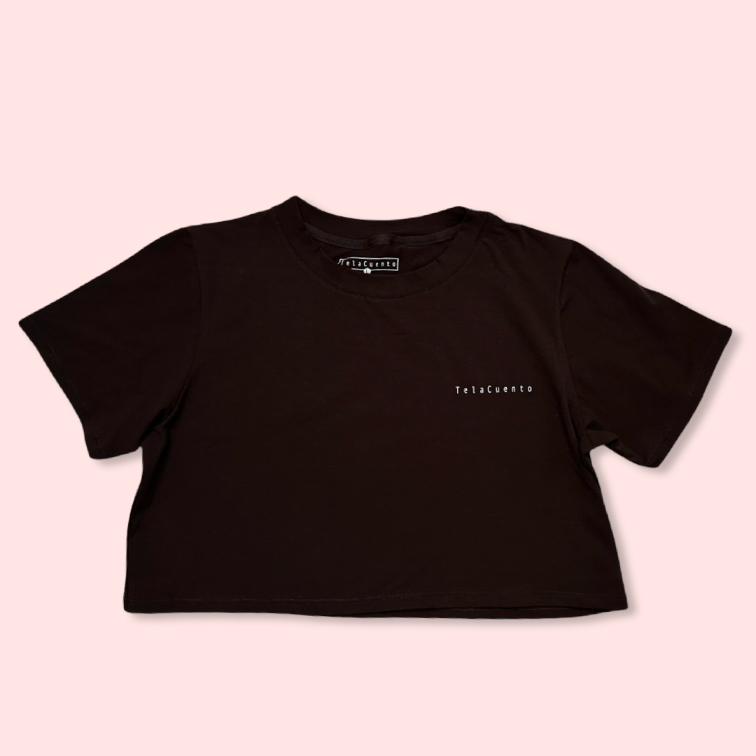 Front view of brown cropped T-shirt with minimal “Telacuento” logo printed on the chest.