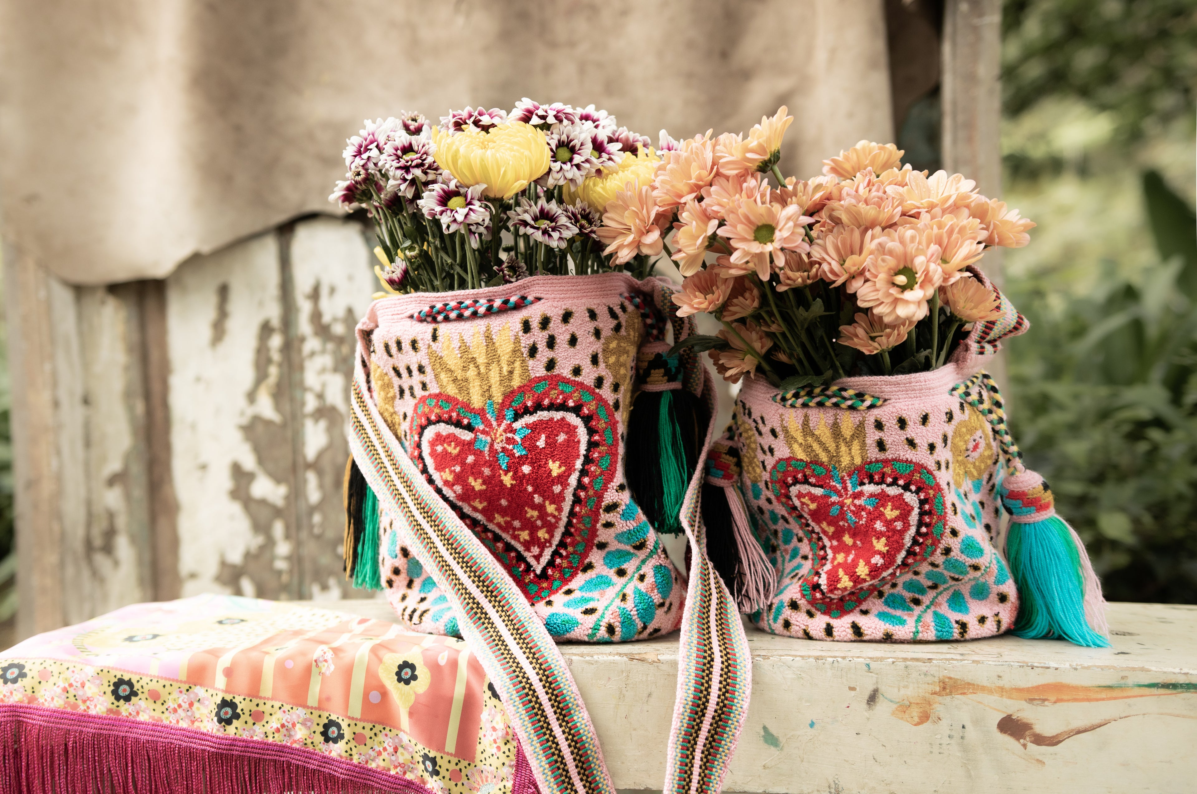 Heart Embroidered Wayuu tapestry handbags displayed together, highlighting intricate handwoven patterns and bold colours